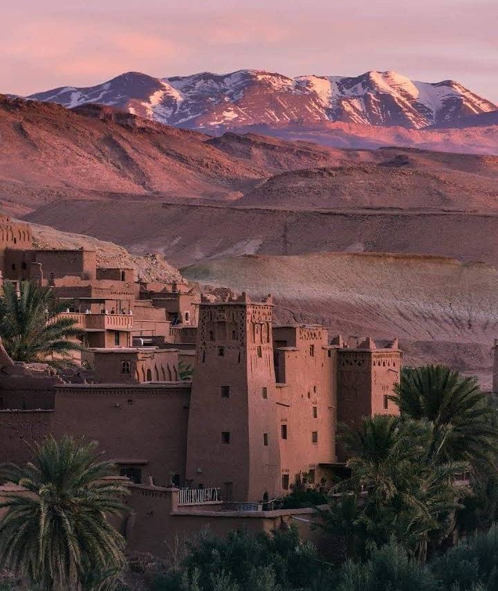 The historic clay fortress of Ait Benhaddou Kasbah under the Atlas Mountains sky