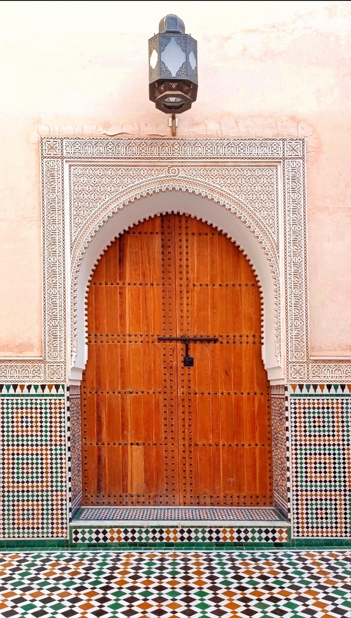Intricate Moroccan Zellij tilework and traditional carved wooden door geometry art